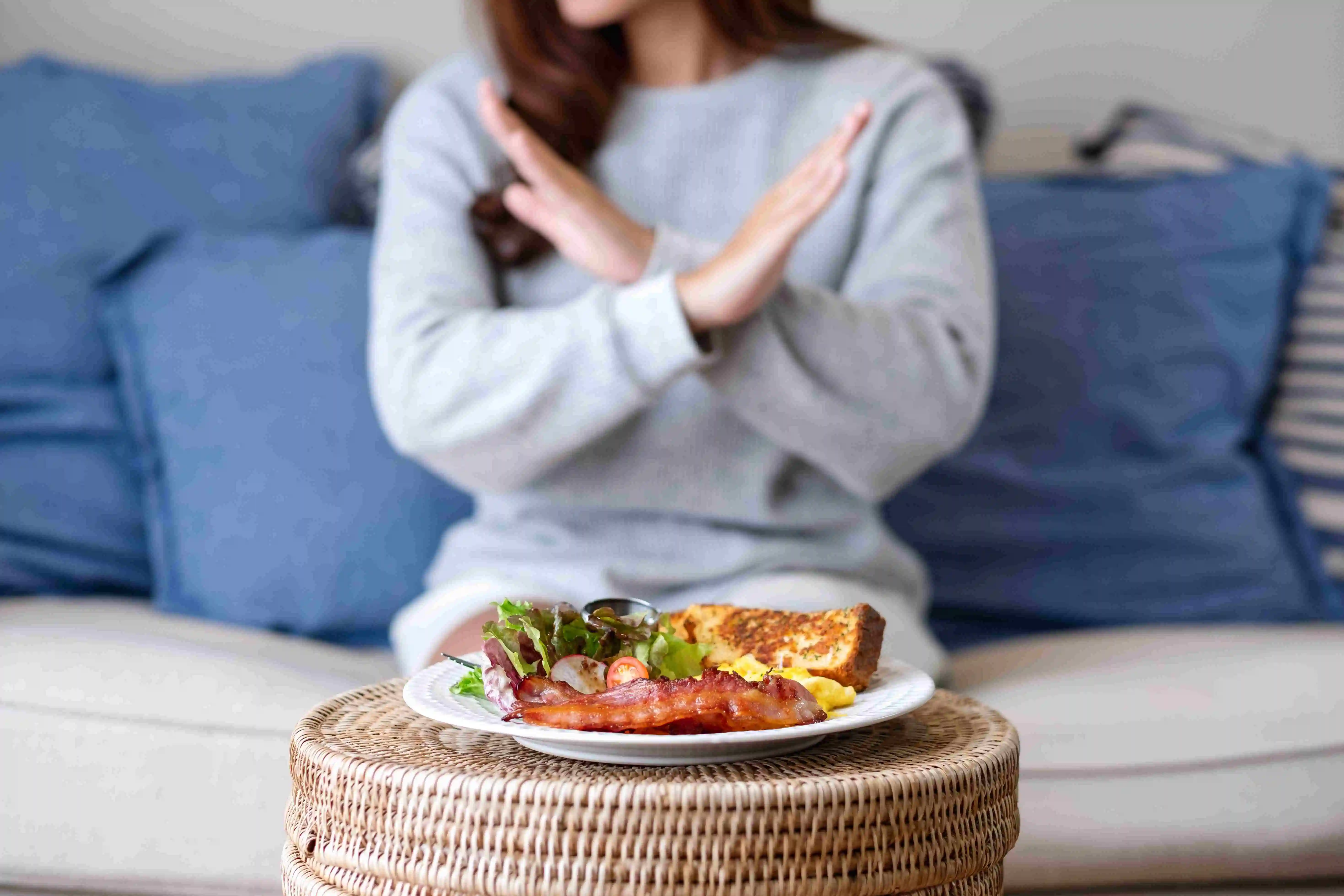 a woman making crossed arms hand sign to no Hard Foods